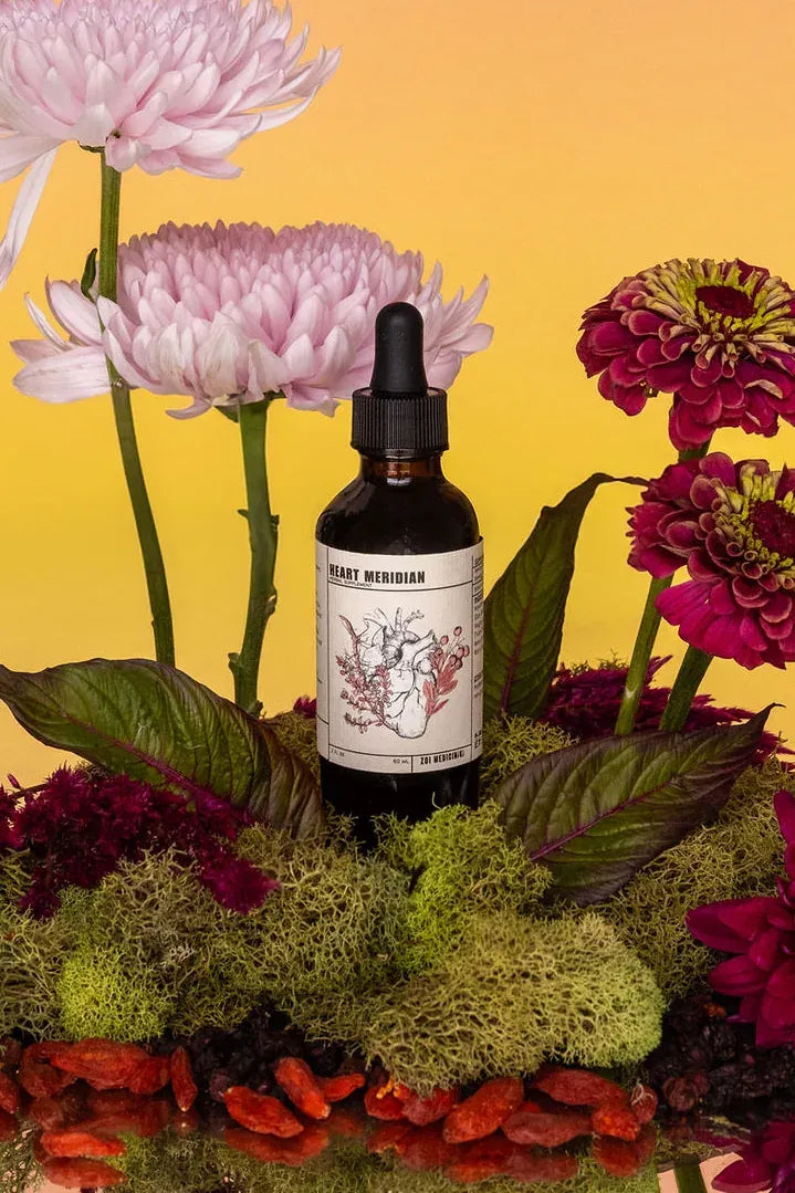 Heart Meridian herbal tincture among garden flowers and herbs